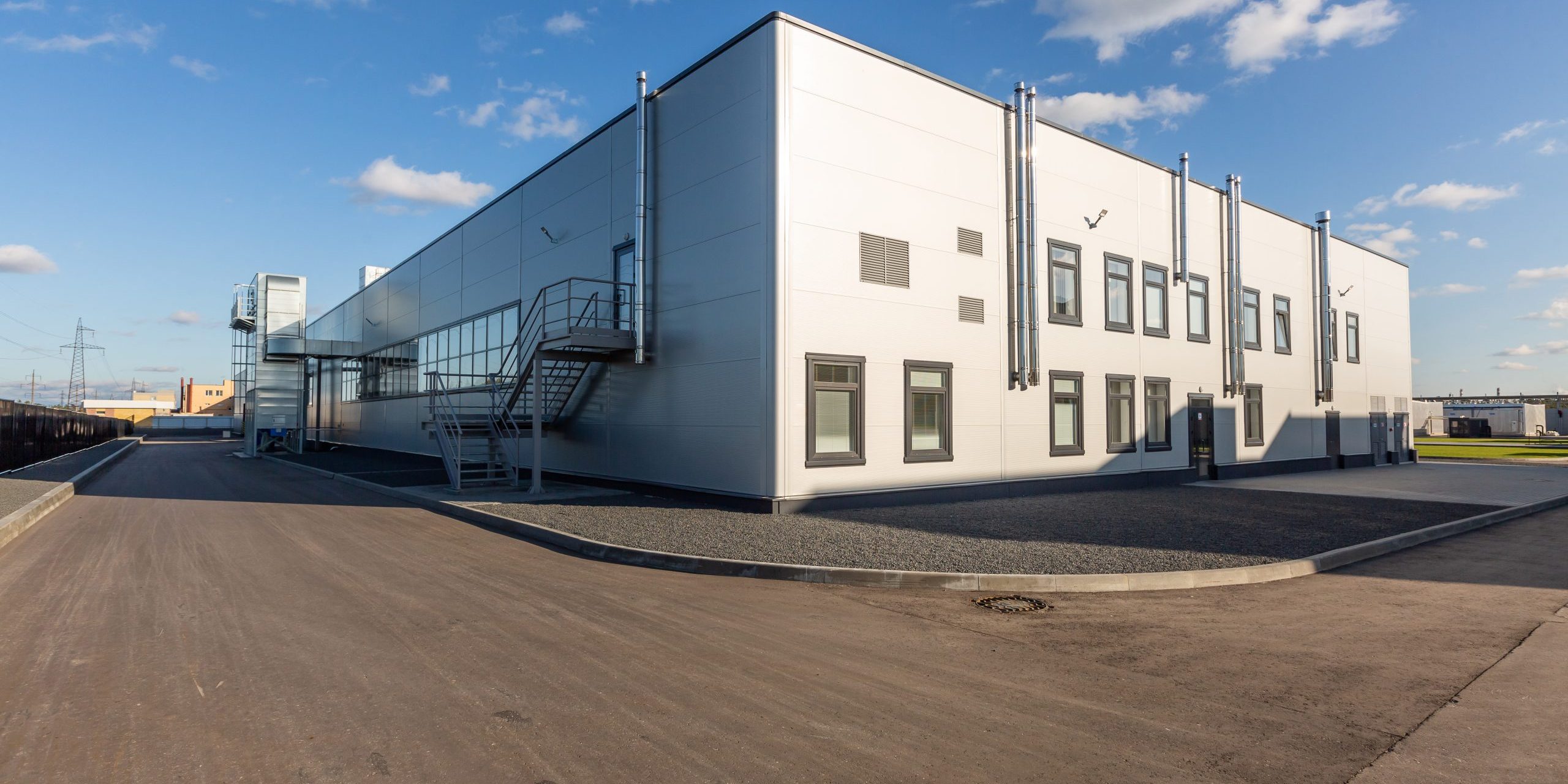 industrial enterprise appearance. Summer day, blue sky, small metal case