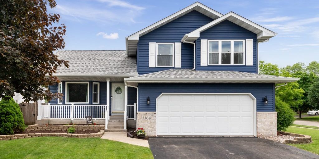 Exterior of a suburban home with blue siding, a white front porc